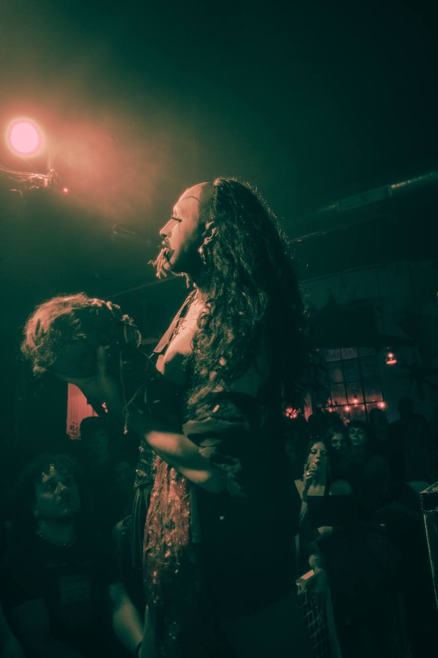 wiqi performing amid the crowd, lit in green
